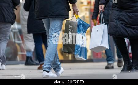 Hamburg, Deutschland. 23rd Dez 2021. Passanten laufen am Tag vor Weihnachten mit Einkaufstaschen durch die Innenstadt. Quelle: Markus Scholz/dpa/Alamy Live News Stockfoto