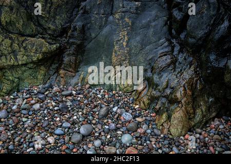 Farbenfrohe Felsen und Kieselsteine auf der Isle of Iona. Stockfoto