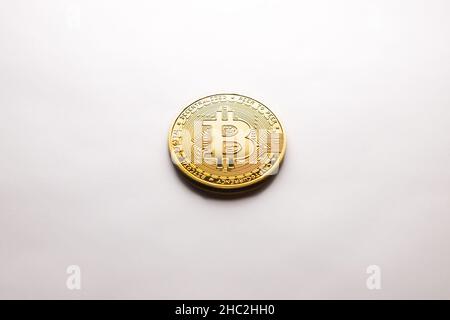 Eine einzelne Krypto-Bitcoin-Goldmünze, fotografiert auf weißem Hintergrund, als Produktaufnahme Stockfoto