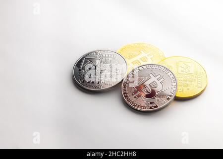 Mehrere Krypto-Bitcoin-Gold- und Silbermünzen, fotografiert auf weißem Hintergrund, als Produkt-Shooting Stockfoto