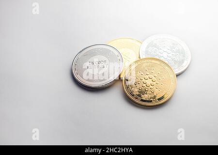 Mehrere Krypto-Cardano-Silber- und Goldmünzen, fotografiert auf weißem Hintergrund, als Produkt-Shooting Stockfoto