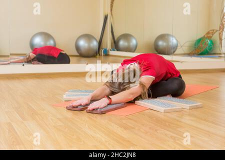 Praxis des Stehens auf Nägeln. Nahaufnahme eines Yoga-Mannes, der auf einem Sadhu-Brett mit scharfen Nägeln steht. Hölzernes Sadhu-Brett mit Nägeln für die Sadhu-Praxis Stockfoto