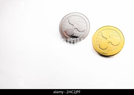 Mehrere XRP-Ripple Silber- und Goldmünzen, fotografiert auf weißem Hintergrund, als Produktaufnahme Stockfoto