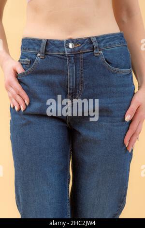 Eine Frau in Kleidung auf dem Hintergrund im Studio, passend für Kleidung Stockfoto