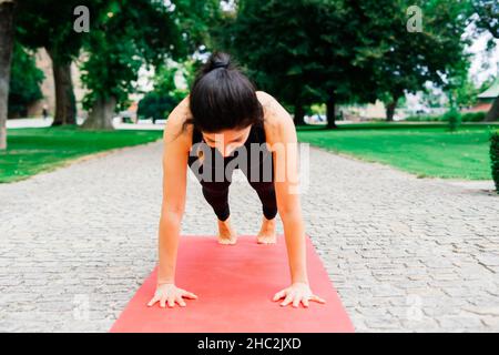 Reife asiatische Frau tut Yoga-Training in einem Park. Konzept des Lebensstils Fitness und gesund. Stockfoto
