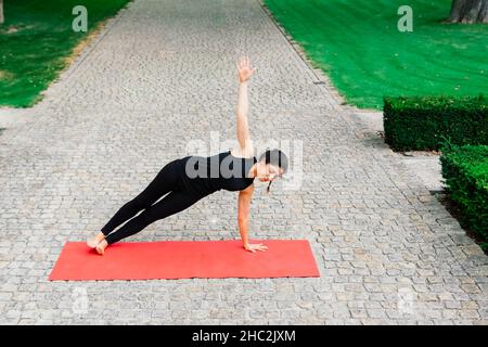 Reife asiatische Frau tut Yoga-Training in einem Park. Konzept des Lebensstils Fitness und gesund. Stockfoto