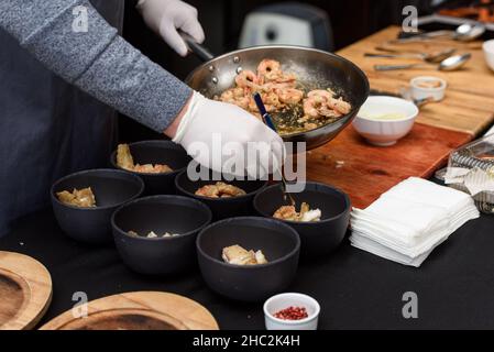 Kochvorgang der Suquet de Peix-Suppe mit Kartoffeln, Kräutern und Fisch mit der Zugabe von Picada close-up in einem Topf auf dem Tisch. Stockfoto
