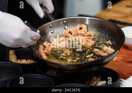 Kochvorgang der Suquet de Peix-Suppe mit Kartoffeln, Kräutern und Fisch mit der Zugabe von Picada close-up in einem Topf auf dem Tisch. Stockfoto