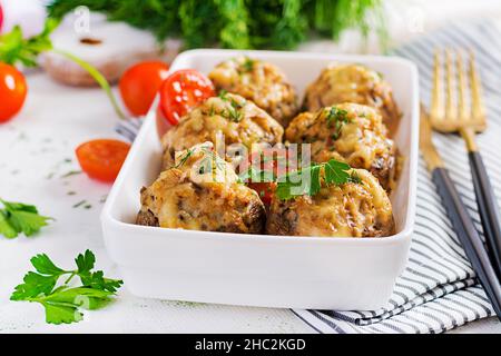 Gebackene Pilze gefüllt mit Hühnerfleisch, Käse und Kräutern auf Leuchtplatte. Stockfoto