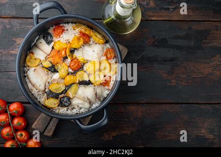 Eine Pfanne fabelhafter Fisch, mit Basmati-Reis und Kirschtomaten, auf altem Holztisch, Draufsicht mit Platz für Text Stockfoto