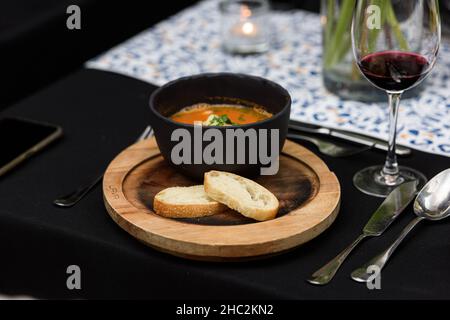 Meeresfrüchte würzige Suppe mit Kartoffeln, Garnelen, Kräutern und Fisch aus einem Picad in einer Pfanne mit Toast serviert Nahaufnahme. Horizontal Stockfoto
