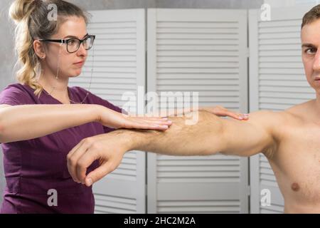 Wiederherstellung der Beweglichkeit des Arm- und Schultergelenks nach einer Verletzung. Büro des Physiotherapeuten. Rehabilitation Stockfoto