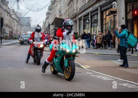 London, England, Großbritannien. 23rd Dez 2021. Motorradfahrer, die als Weihnachtsmann verkleidet sind, fahren durch die Regent Street. (Bild: © Tayfun Salci/ZUMA Press Wire) Stockfoto