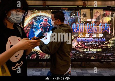 Fußgänger kommen an einer Werbetafel der Marvel-Comicfigur Spider-man 'No Way Home Movie vorbei, die von Columbia Picters koproduziert und von Sony Picters vertrieben wird, in Hongkong. Stockfoto