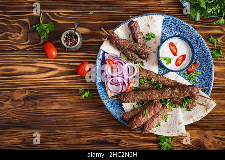 Türkisch und Arabisch traditionellen Ramadan mix Kebab Platte. Adana Kebab, Huhn, Lamm und Rind auf lavash Brot mit Soße. Ansicht von oben Stockfoto