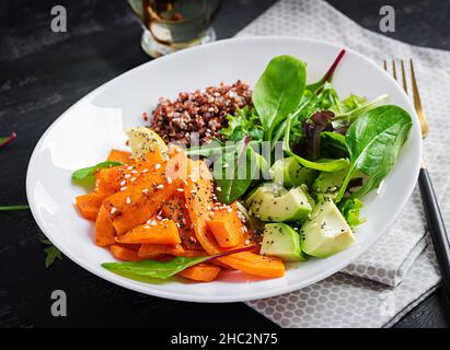 Vegane Mahlzeiten, Mittagessen. Buddha-Schale mit Quinoa, gebratenem Kürbis, Avocado und grünen Kräutern. Vegetarische, gesunde Ernährung Konzept. Stockfoto