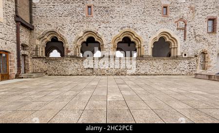 Vianden, Luxemburg. 25. September 2021. Innenhof des Schlosses, leere, gemauerte Mauer mit riesigen Bogenfenstern im Hintergrund, kalter Sommermorgen Stockfoto