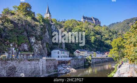 Vianden, Luxemburg. 25. September 2021. Unser Fluss mit einer Ziegelmauer mit einem Teil, der vom großen Sturm gebrochen wurde, Häuser auf der Seite eines Berges mit dem Abguss Stockfoto