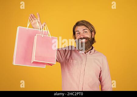 Schöner Kauf. Geburtstagsüberraschung bei der Party. Mann mit Paket. Bereiten Sie sich auf Urlaub. Bestes Angebot. Glücklicher bärtiger Mann mit Geschenk-Pack. Fröhlich Stockfoto