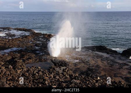 Das Blowhole des Spouting Horns, das mit einer Wasserwolke ausbricht, die 10 Fuß in die Luft in Kauai sprüht Stockfoto