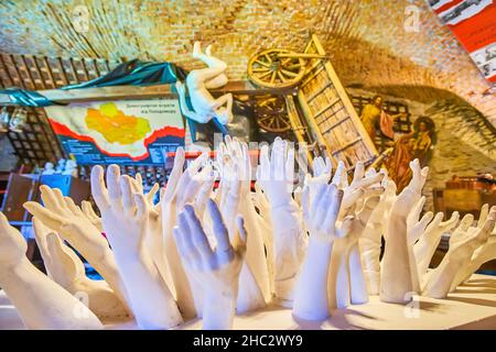 MEDZHYBIZH, UKRAINE - 13. JULI 2021: Innenansicht des Holodomor-Museums in der Burg Medzhybizh mit Stuckskulptur, die die Aufzucht von han darstellt Stockfoto