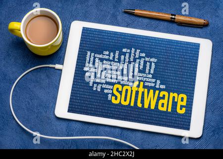 Computer-Software Wort-Cloud mit Null ein binärer Hintergrund auf digitalen Tablet mit einer Tasse Kaffee, Technologie und Geschäftskonzept Stockfoto