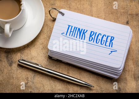 Denken Sie an größere motivierende Erinnerungen oder Ratschläge - Handschrift auf einer Karteikarte mit einer Tasse Kaffee, Business und Lifestyle-Konzept Stockfoto