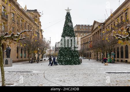 Pamplona, Spanien - 28. November 2021 - Avenue Carlos III schneit. Weihnachtsbaum im Zentrum und Palast von Navarra auf der rechten Seite. Stockfoto