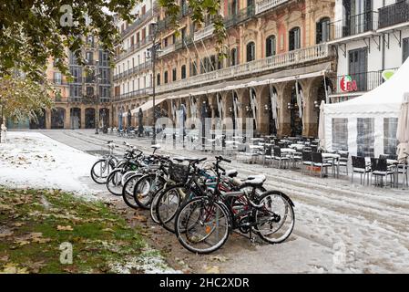 Pamplona, Spanien - 28. November 2021 - Fahrräder, die auf dem Platz Plaza del Castillo stehen, während es schneit. Stockfoto