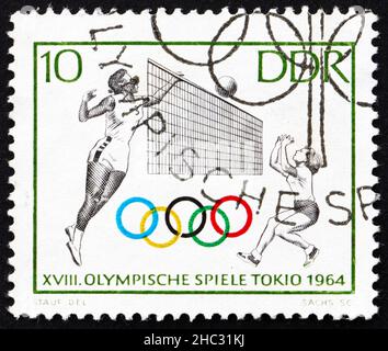 DDR - UM 1964: Eine in der DDR gedruckte Briefmarke zeigt Volleyball, 18th Olympische Spiele, Tokio 64, um 1964 Stockfoto