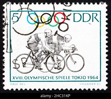 DDR - UM 1964: Eine in der DDR gedruckte Briefmarke zeigt Radfahren, 18th Olympische Spiele, Tokio 64, um 1964 Stockfoto