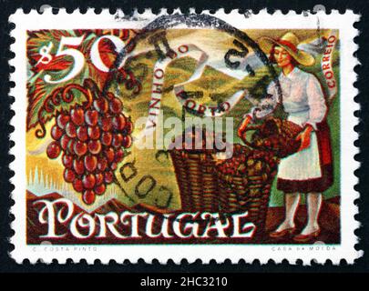 PORTUGAL - UM 1970: Eine in Portugal gedruckte Marke zeigt Trauben und Frauen, die Körbe füllen, Portwein Export, um 1970 Stockfoto