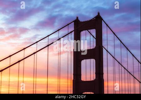 Die legendäre Golden Gate Bridge steht hoch vor einem atemberaubenden Sonnenaufgangshimmel. Stockfoto