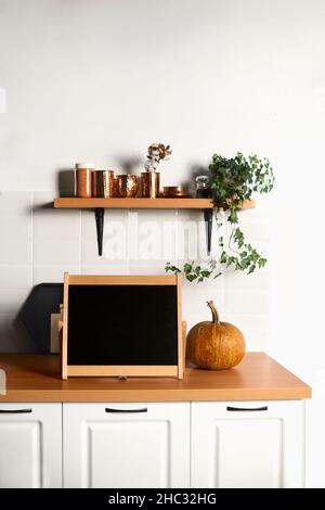 Schwarzes Briefbrett auf der Küchenarbeitsplatten Nahaufnahme. Teil der Innenküche. Vertikaler Rahmen. Stockfoto