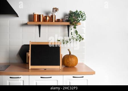 Schwarzes Briefbrett auf der Küchenarbeitsplatten Nahaufnahme. Teil der Innenküche. Horizontaler Rahmen. Stockfoto