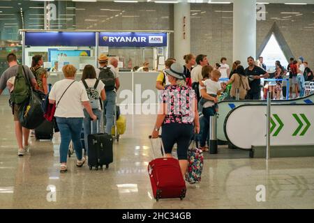 Palma, Spanien - 25. September 2019: Touristen, die ihre Gepäckwagen in der Flughafenhalle ziehen, während sie zum Abflugsteig zum Einsteigen gehen, Ryan Stockfoto