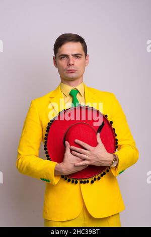 Porträt eines glücklichen selbstbewussten Geschäftsmannes in gelbem Anzug und Krawatte, isoliert auf weißem Hintergrund. Stockfoto