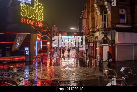 Hamburg, Deutschland. 23rd Dez 2021. Nur wenige Besucher flanieren über die große Freiheit auf der Hamburger Reeperbahn. Für die Gastronomie gilt ab dem 24. Dezember: Aufgrund der Corona-Pandemie müssen Restaurants, Pubs und Bars ab 11 Uhr schließen. Quelle: Axel Heimken/dpa/Alamy Live News Stockfoto