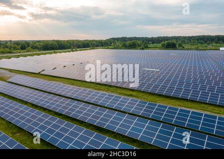 Riesiges Solarkraftwerk zur Nutzung von Solarenergie in einem malerischen grünen Feld in der Ukraine. Stockfoto
