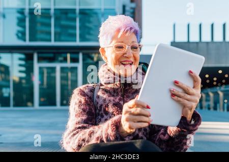 Italien, modische ältere Frau mit Tablet in der Stadt Stockfoto