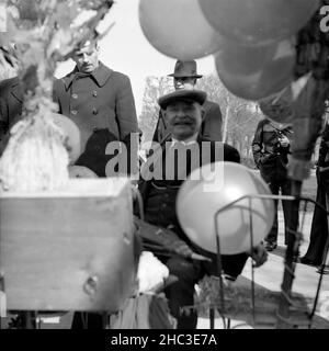 Zwei Fotos einer Szene, in der Kinder 1945 in einem nicht identifizierten Pariser Park Luftballons bekommen. Ein Foto zeigt drei Eltern, drei stehende Kinder und ein teilweise verdunkeltes Baby in einem Kinderwagen. Das andere Foto zeigt einen lächelnden Ballon-Mann (etwas unscharf), der von mehreren Männern umgeben ist. Einige der Männer tragen Uniformen. Stockfoto