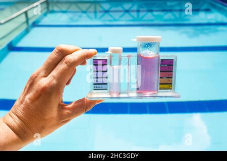 Mini-Wasser-Testkit mit Handgriff auf dem Boden des Pools. Reagenz für kolorimetrische Tests. Stockfoto