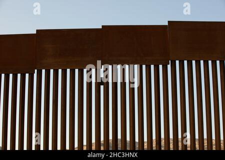 Am Nachmittag scheint der Sonnenuntergang an der Grenzmauer zwischen den USA und Mexiko in der Innenstadt von Tecate, Baja, Mexiko. Stockfoto