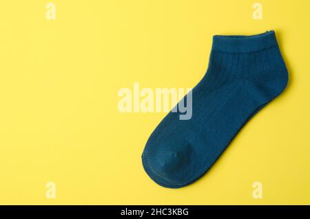 Die dunkelblauen Socken auf gelbem Hintergrund und Platz für Text. Stockfoto