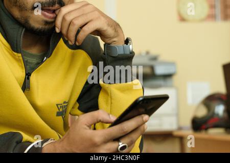 Eine Person, die an seinem Smartphone arbeitet. Die Person auf dem Bild betreibt das Telefon mit zwei Händen Stockfoto