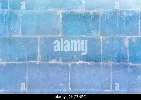 Die strukturierte Oberfläche einer transluzenten großen Eiswand aus großen Ziegeln. Stockfoto