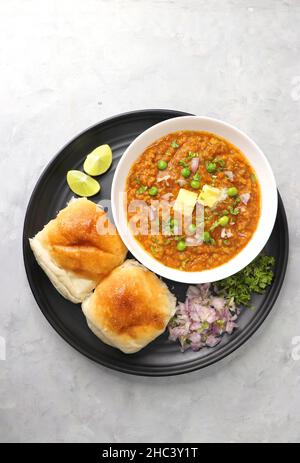 Pav Bhaji im indischen Stil der Mumbai Street, garniert mit Erbsen, rohen Zwiebeln, Koriander und Butter. Mit pav gebratene. Stockfoto