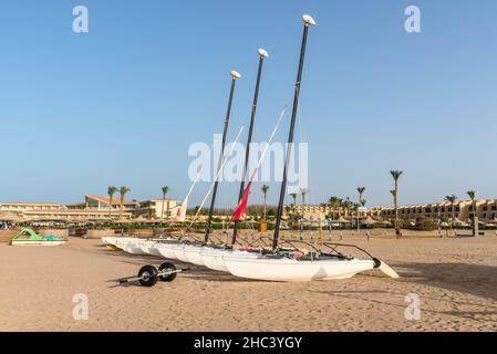 Hurghada, Ägypten - 01. Juni 2021: Segelkatamarane liegen auf dem Sand und warten auf Touristen in der Makadi Bay, einer von Ägyptens schönen Riviera am Roten Meer. Stockfoto