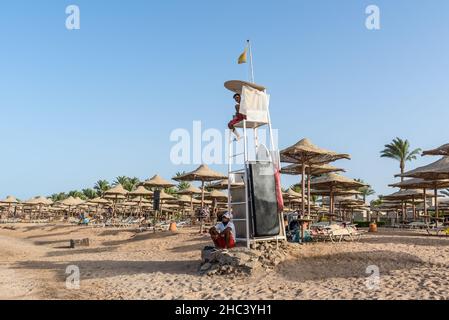 Hurghada, Ägypten - 01. Juni 2021: Rettungsschwimmer auf dem Aussichtsturm überprüfen die Menschen, die im Meer in Makadi Bay schwimmen, die einer von Ägypten schönen roten Stockfoto