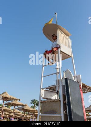 Hurghada, Ägypten - 01. Juni 2021: Rettungsschwimmer auf dem Aussichtsturm überprüfen die Menschen, die im Meer in Makadi Bay schwimmen, die einer von Ägypten schönen roten Stockfoto